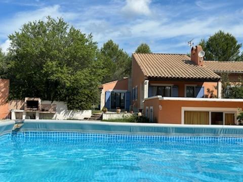 une grande piscine bleue devant une maison dans l'établissement Location saisonnière villa Lauris, à Lauris