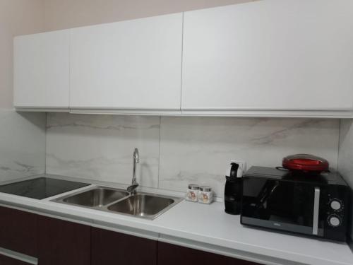 Una encimera de cocina con fregadero y microondas. en Andrea House, en Berat