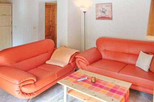 ein Wohnzimmer mit zwei orangenen Sofas und einem Couchtisch in der Unterkunft Ferienhaus Herz in Lübbenau