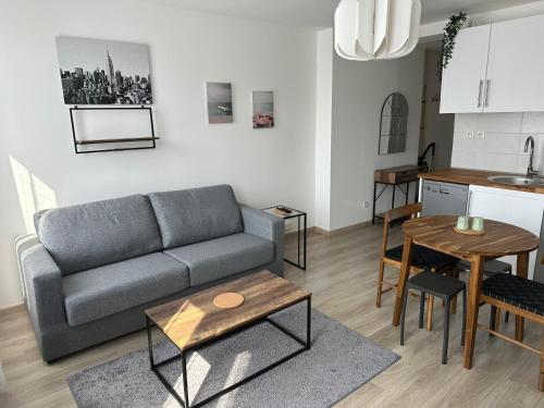 un salon avec un canapé et une table dans l'établissement Appartement agréable et confortable pour 4 personnes, au Havre