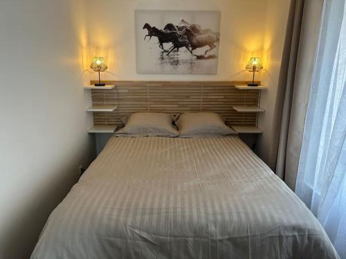 - une chambre avec un grand lit et deux lampes dans l'établissement Appartement agréable et confortable pour 4 personnes, au Havre