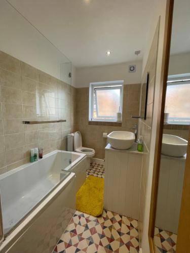 La salle de bains est pourvue d'une baignoire, d'un lavabo et de toilettes. dans l'établissement Nottingham Home Stay, à Nottingham