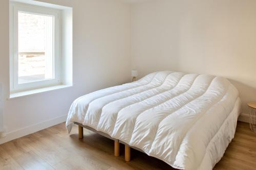 a white bed in a room with a window at À 100m du port de Loctudy, bel appartement pour 6 in Loctudy