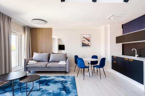 a living room with a couch and a table and chairs at Art Boulevard in Mrzeżyno