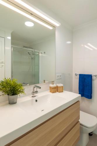 a bathroom with a sink and a toilet and a mirror at El Refugio de Pilar in Melenara