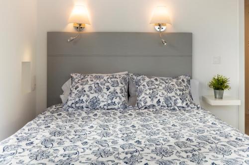 メレナラにあるEl Refugio de Pilarのベッド1台(青と白の掛け布団、ランプ2つ付)