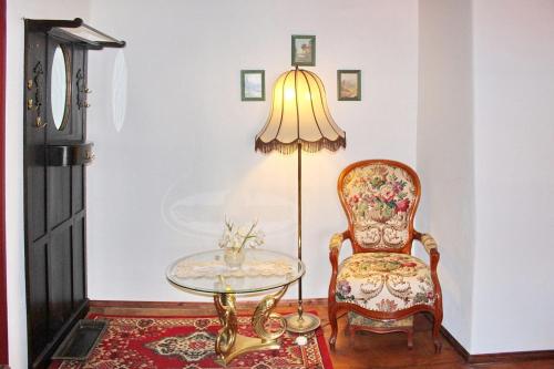 una camera con tavolo, sedia e lampada di Haus Zeitlos Ferienwohnung Zeitreise a Lübbenau