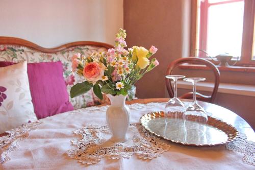einen Tisch mit einer Vase mit Blumen darauf in der Unterkunft Haus Zeitlos Ferienwohnung Zeitreise in Lübbenau