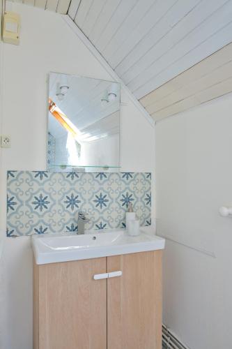 une salle de bain avec un lavabo et un miroir dans l'établissement Parenthese bretonne a Penmarch, à Penmarcʼh