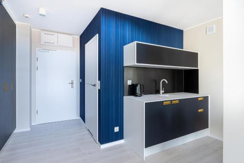 a kitchen with a sink and a blue wall at Art Boulevard in Mrzeżyno