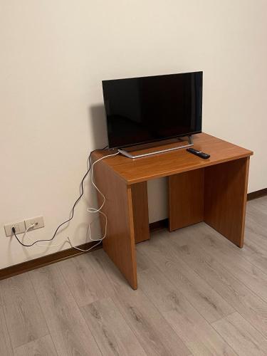 TV sentada en un escritorio de madera en una habitación en Albergo Civico 7, en Leno