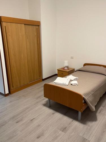 1 dormitorio con 1 cama y puerta de madera en Albergo Civico 7, en Leno