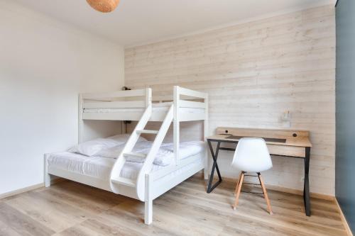 a bedroom with a bunk bed and a desk at Ambiance paisible sur la côte vendéenne in La Barre-de-Monts