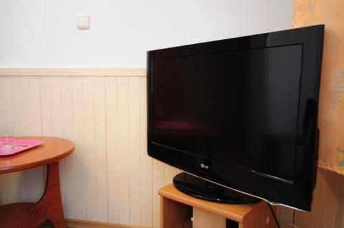 una TV a schermo piatto seduta sopra un tavolo di Hotel Wysoka Brama a Olsztyn