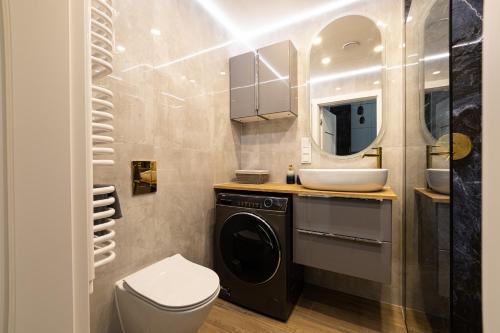ein Badezimmer mit einer Waschmaschine und einem Waschbecken in der Unterkunft 2Homerent Shellter 117 in Rogowo