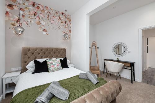 a bedroom with a large bed and a chair at Finest Retreats - Peace Retreats Apartment, Pwllheli in Pwllheli