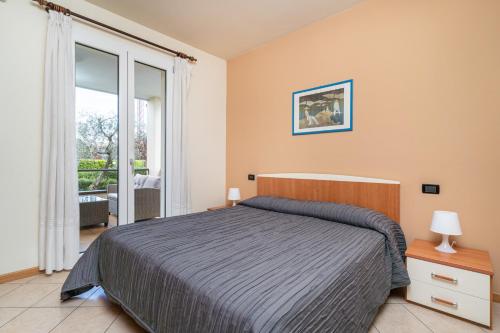 a bedroom with a bed and a large window at Residence Primera in Moniga