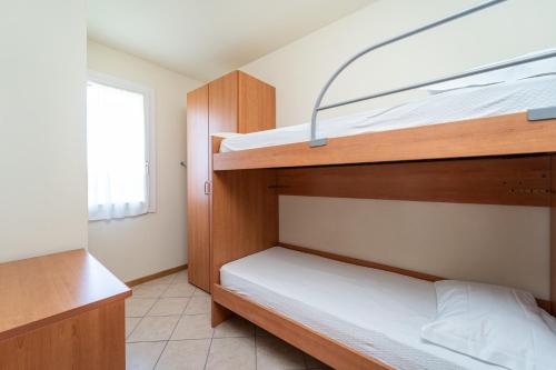a bedroom with two bunk beds and a window at Residence Primera in Moniga