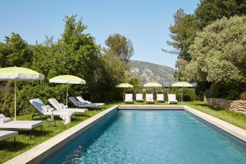 - une piscine avec des chaises longues et des parasols à côté dans l'établissement La Bastide du Mourre, à Oppède