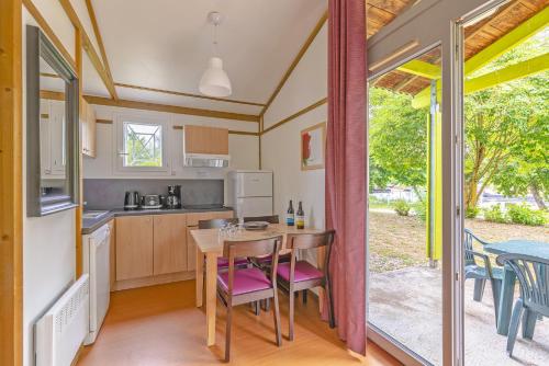 a kitchen and dining room with a table and chairs at Lagrange Grand Bleu Vacances – Résidence Port Lalande in Castelmoron-sur-Lot