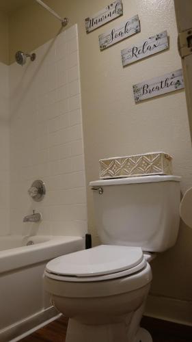 a bathroom with a white toilet and a bath tub at Blue Lagoon near Apple in Santa Clara
