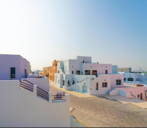 a view of a city with white and blue buildings at Mina Hotel and Residences By The Torch in Doha