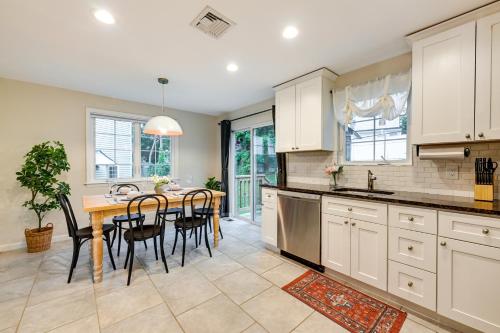 a kitchen with white cabinets and a table with chairs at Glen Cove Vacation Rental Less Than 1 Mi to Downtown! in Glen Cove