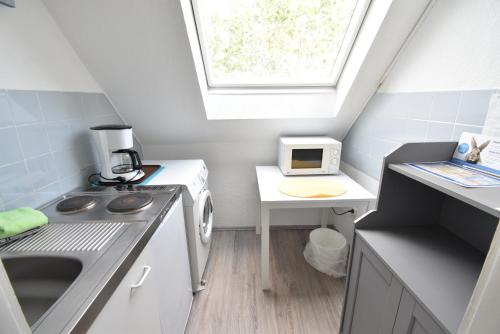 a small kitchen with a sink and a window at CoreRooms - kleines Apartment Essen Kray in Essen