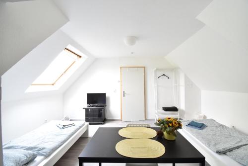 a white room with two beds and a table at CoreRooms - kleines Apartment Essen Kray in Essen