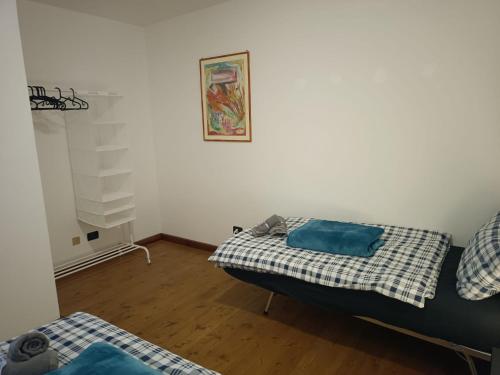 a room with two beds and a picture on the wall at Casa Vacanze Lavanda & Rosmarino in Telve