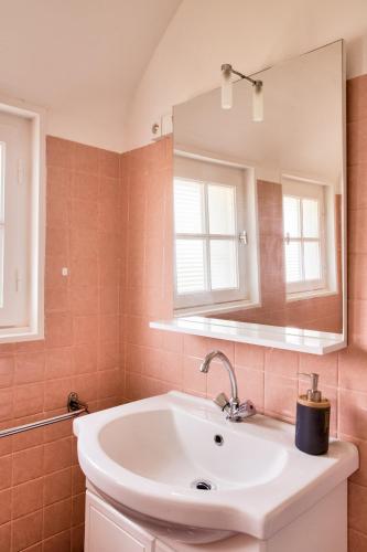 une salle de bain avec un lavabo et un miroir dans l'établissement 700m plage - maison pour 8 - Grand jardin, à Penmarcʼh