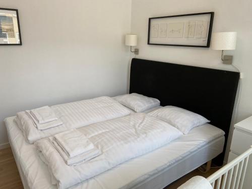 a bed with white sheets and towels on it at City Center Apartments 694 in Copenhagen