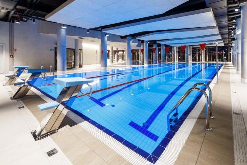 a large swimming pool in a building at NORTH Apartments, SunSetView 507 in Kołobrzeg