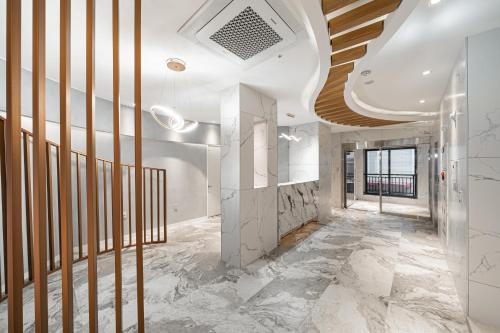 a hallway with marble flooring and a wooden ceiling at Urbanstay Boutique Nampo BIFF in Busan