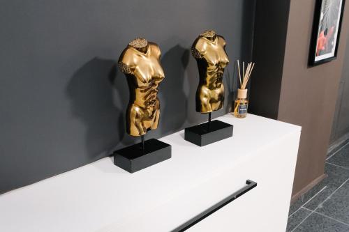 two gold sculptures on display on a white table at Venizelou Comfort & Living II in Kavala