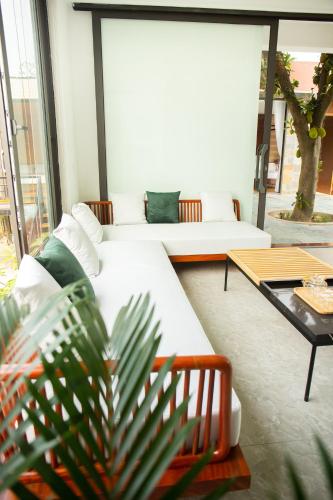 a living room with a white couch and a table at An Sunrise Villa Vinh Phuc in Vĩnh Phúc