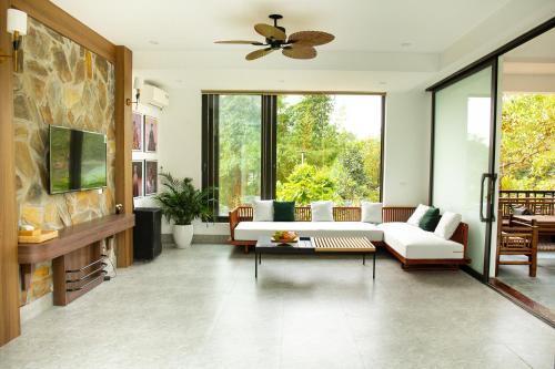 Vĩnh PhúcにあるAn Sunrise Villa Vinh Phucのリビングルーム(白いソファ、天井ファン付)