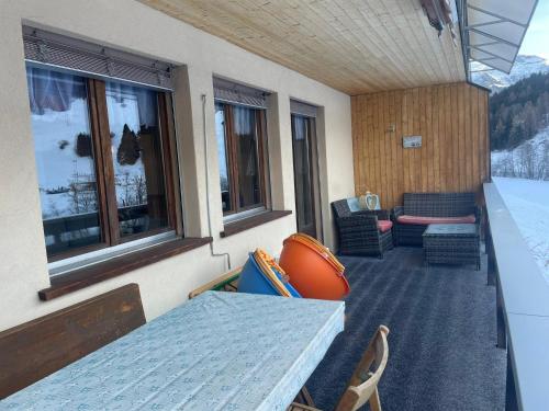 a balcony with a table and chairs and windows at Ferienhaus Somareiva in Savognin