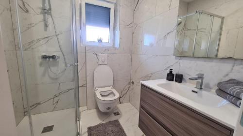 a bathroom with a toilet and a sink and a shower at Gita Suite in Orebić