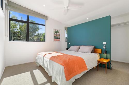 a bedroom with a large bed and a blue wall at Hannah's Bay Hideaway in Rotorua