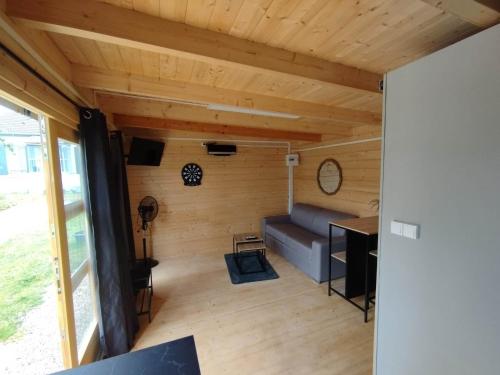 a living room with a couch and a table at Tiny house toute équipée avec jardin in Saint-Florent-sur-Cher