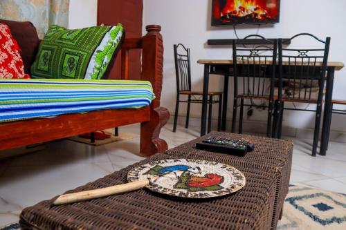 een woonkamer met een tafel met afstandsbediening bij Serene 2 bedroom homestay 15mindrive to the beach in Mombasa