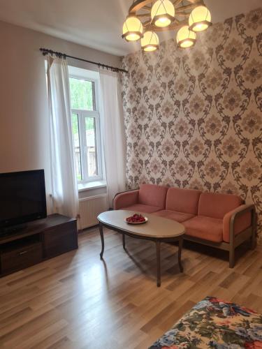 uma sala de estar com um sofá e uma mesa em Sonata em Liepāja