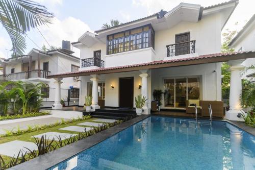a house with a swimming pool in front of it at Eerus Villa 3Bhk Luxurious Home in Arpora