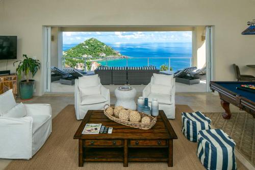 een woonkamer met een pooltafel en uitzicht op de oceaan bij Maria Bluff Estate in Cruz Bay
