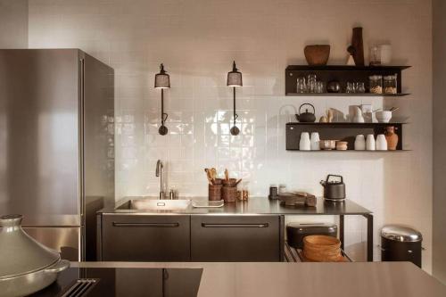 a kitchen with a sink and a stainless steel refrigerator at casa vipp in Andorra la Vella