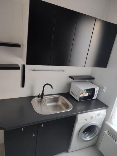 a kitchen with a sink and a washing machine at Apartament Sopot centrum in Sopot