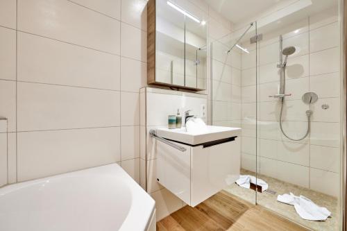 uma casa de banho branca com um lavatório e um chuveiro em BergIdylle 1 em Garmisch-Partenkirchen