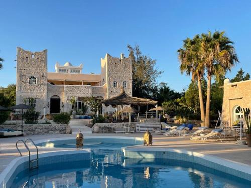 un resort con piscina di fronte a un edificio di Out of Medina a Essaouira