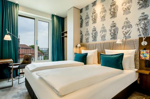 2 Betten in einem Hotelzimmer mit Fenster in der Unterkunft Motel One Dresden am Zwinger in Dresden